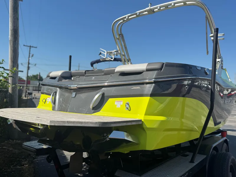 Slide: The Image of 2018 MasterCraft XT22 boat with vibrant yellow and gray design on a trailer. - 4