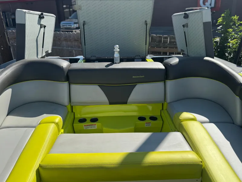 Slide: The Image of 2018 MasterCraft XT22 boat interior with lime green and gray seating. - 7