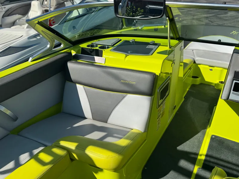 Slide: The Image of 2018 MasterCraft XT22 boat interior with vibrant lime green and gray seating. - 8