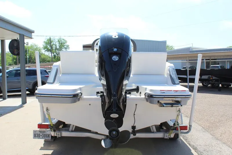 Slide: The Image of 2021 Bayliner T20CC boat rear view with outboard motor in a parking area. - 13