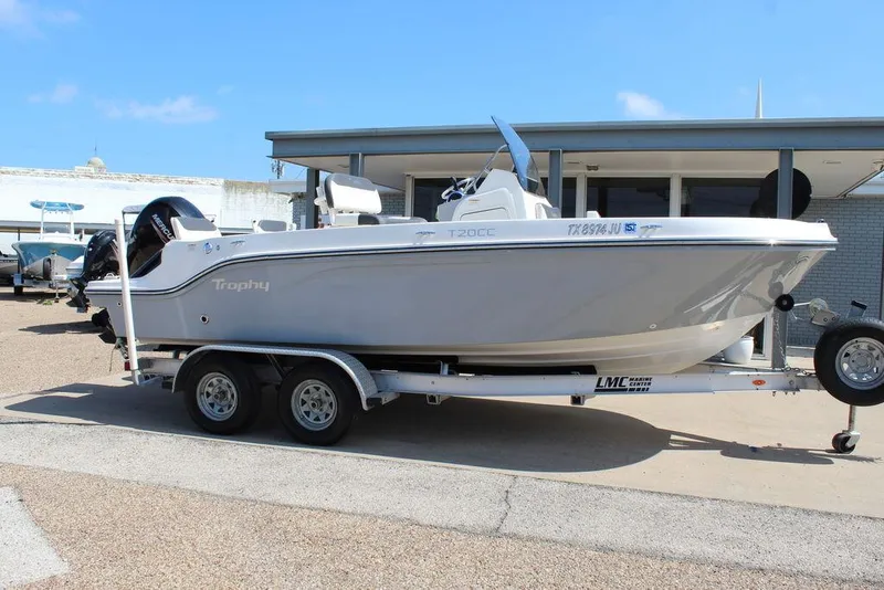 Slide: The Image of 2021 Bayliner T20CC boat on trailer, parked outdoors under clear blue sky. - 15