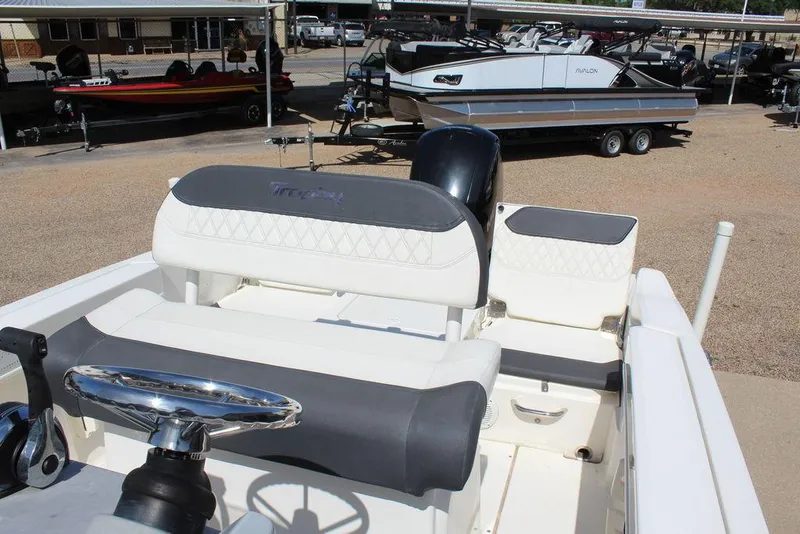 Slide: The Image of 2021 Bayliner T20CC boat interior with steering wheel and seating, parked in a marina. - 4