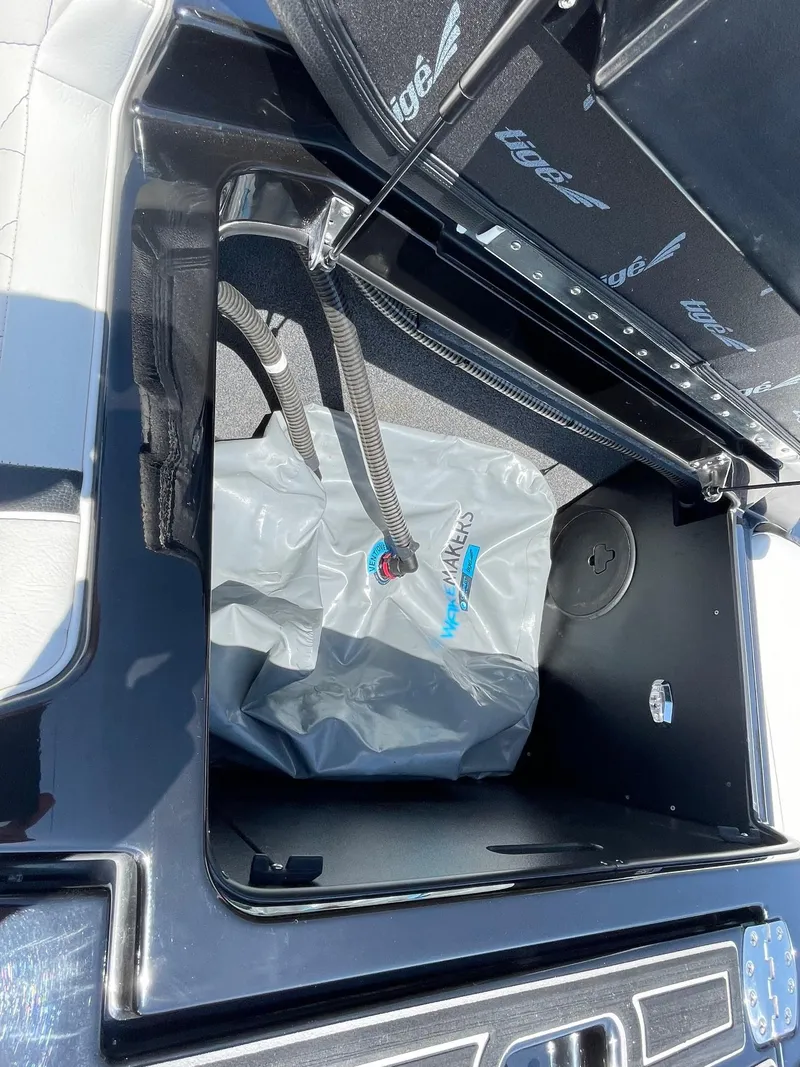 Slide: The Image of 2021 Tigé 23ZX boat storage compartment with ballast bag and hoses. - 14