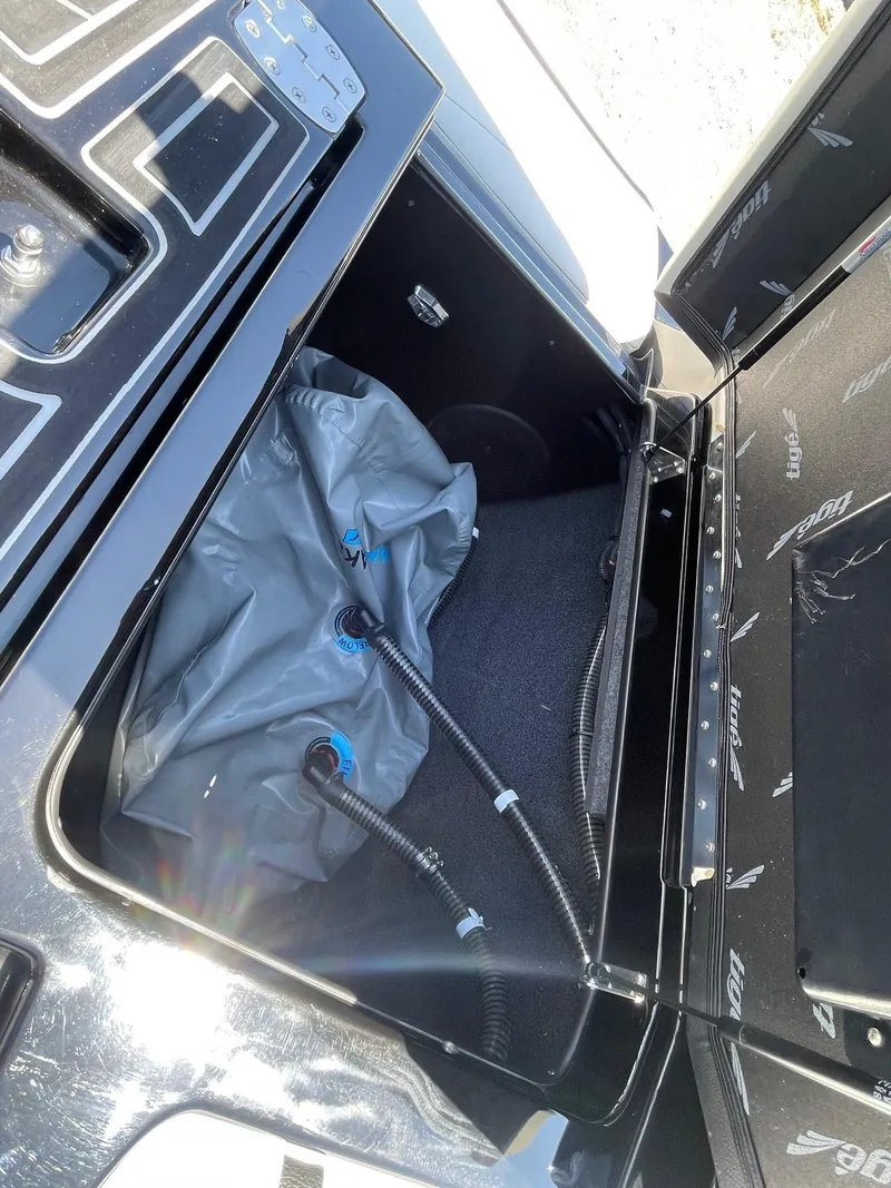Slide: The Image of 2021 Tigé 23ZX boat storage compartment with ballast bag and hoses. - 15