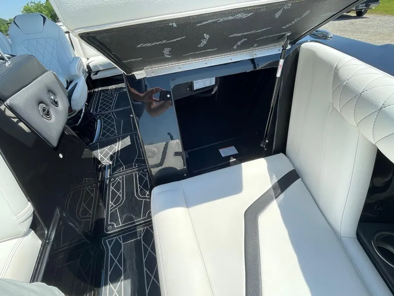 Slide: The Image of 2021 Tigé 23ZX boat interior with white seating and open storage compartment. - 5