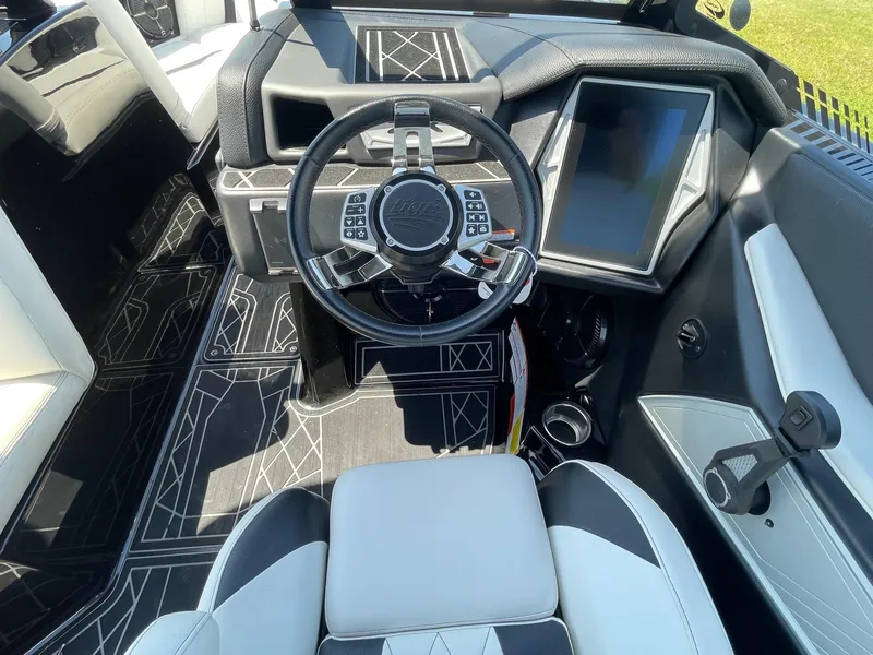 Slide: The Image of 2021 Tigé 23ZX boat cockpit with modern steering wheel and touchscreen controls. - 6