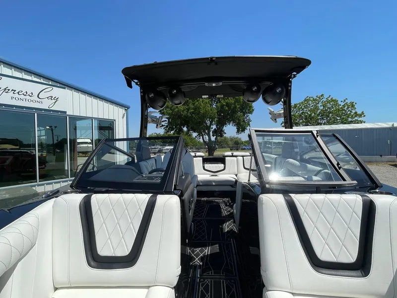 Slide: The Image of 2021 Tigé 23ZX boat interior with white seating and black accents, displayed outdoors. - 9