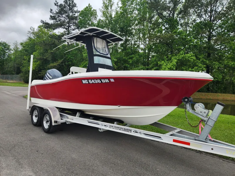 Slide: The Image of Red 2008 Pioneer 197 Sportfish boat on trailer, parked near trees and road. - 1