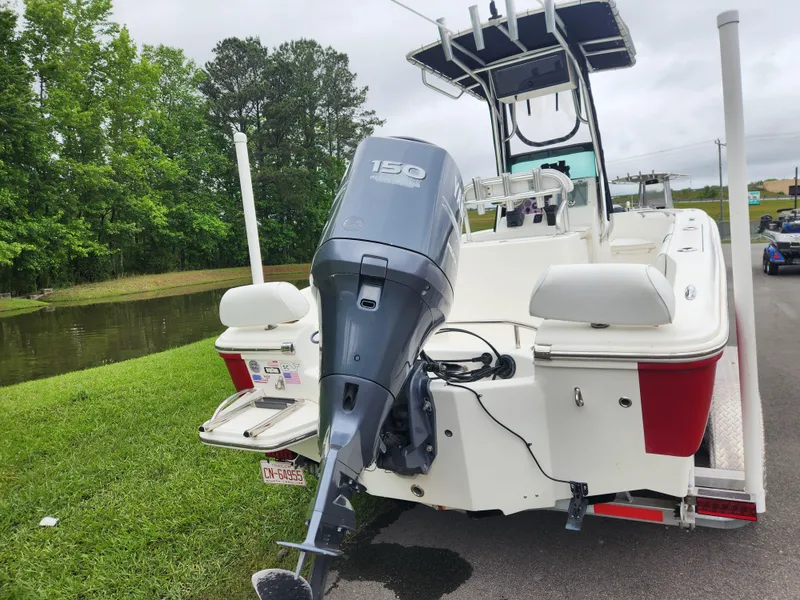 Slide: The Image of 2008 Pioneer 197 Sportfish boat with 150 HP outboard motor, parked near a pond. - 3