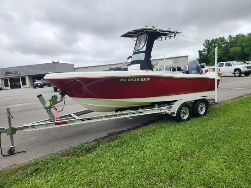 Slide: The Image of 2008 Pioneer 197 Sportfish boat on trailer, red and white, parked on grass. - 4