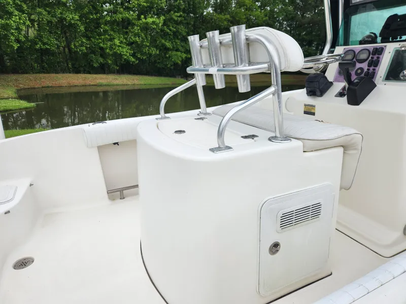 Slide: The Image of 2008 Pioneer 197 Sportfish boat interior with rod holders and seating, near a serene lake. - 9