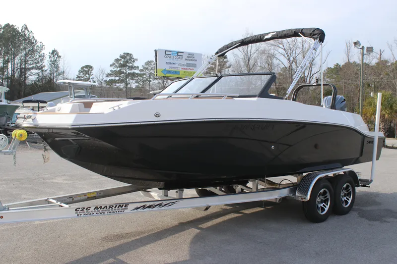 Slide: The Image of 2025 Starcraft SVX 210 OB DC boat on trailer, black and white design, parked outdoors. - 1