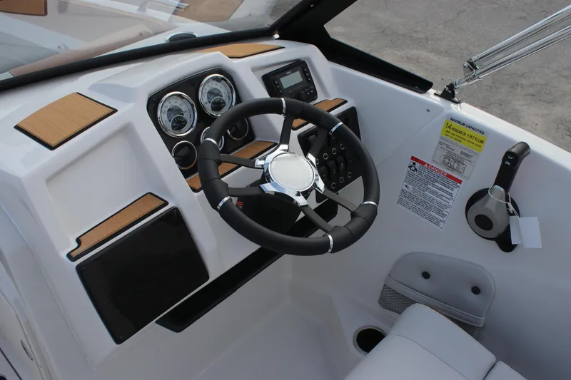 Slide: The Image of 2025 Starcraft SVX 210 OB DC boat dashboard with steering wheel and control panel. - 10