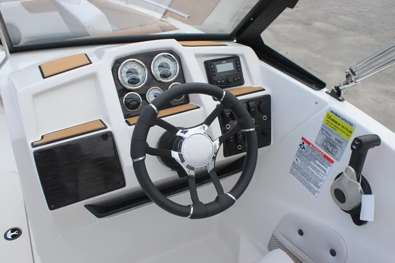 Slide: The Image of 2025 Starcraft SVX 210 OB DC boat dashboard with steering wheel and control panel. - 15