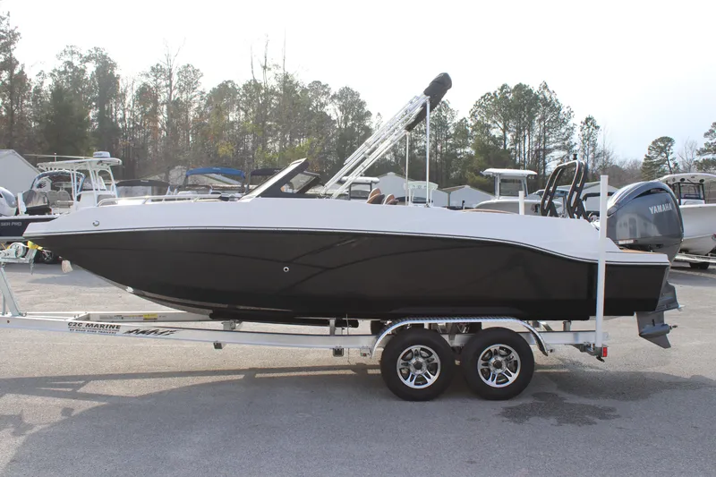 Slide: The Image of 2025 Starcraft SVX 210 OB DC boat on trailer, black and white design, parked outdoors. - 3