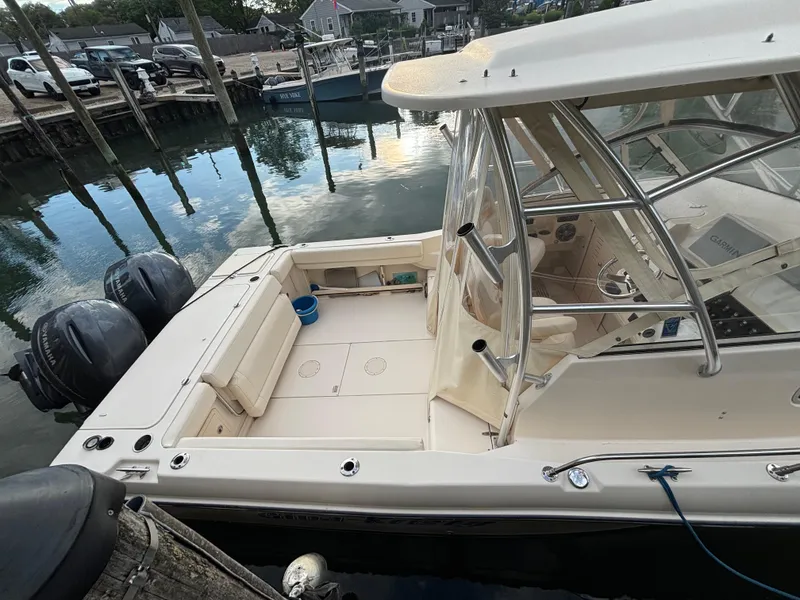 Slide: The Image of 2021 Grady-White Gulfstream 232 boat docked, featuring spacious deck and dual outboard motors. - 14