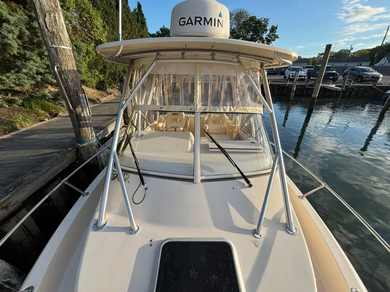 Slide: The Image of 2021 Grady-White Gulfstream 232 boat docked, featuring Garmin equipment and clear skies. - 19