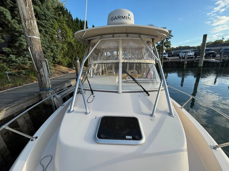 Slide: The Image of 2021 Grady-White Gulfstream 232 boat docked, featuring Garmin equipment and clear skies. - 22