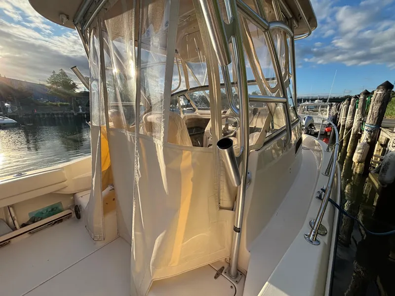 Slide: The Image of 2021 Grady-White Gulfstream 232 boat docked, featuring enclosed cabin and stainless steel framework. - 27