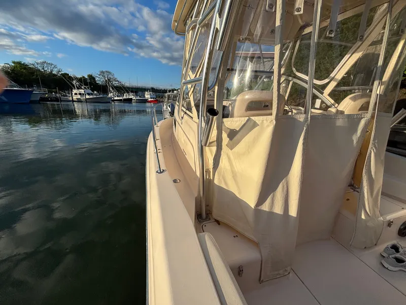 Slide: The Image of 2021 Grady-White Gulfstream 232 boat docked, featuring a spacious deck and clear skies. - 29