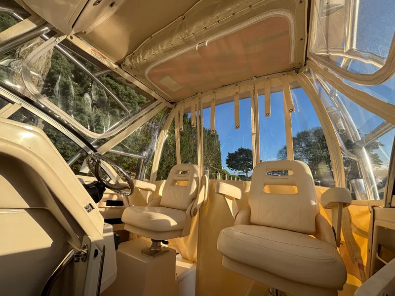 Slide: The Image of 2021 Grady-White Gulfstream 232 boat interior with beige seating and clear canopy. - 31