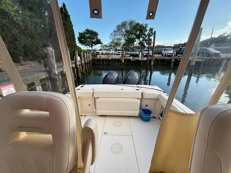 Slide: The Image of 2021 Grady-White Gulfstream 232 boat interior at dock, featuring dual engines and seating. - 33