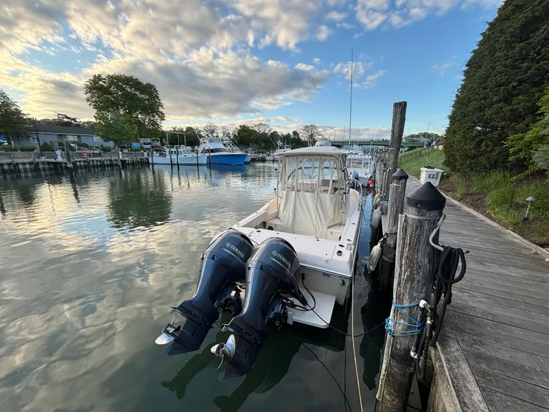 Slide: The Image of 2021 Grady-White Gulfstream 232 boat docked by a wooden pier under a partly cloudy sky. - 39