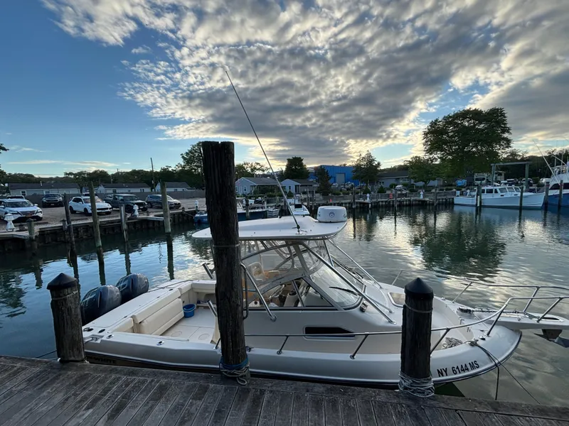 Slide: The Image of 2021 Grady-White Gulfstream 232 boat docked at a serene marina during sunset. - 41