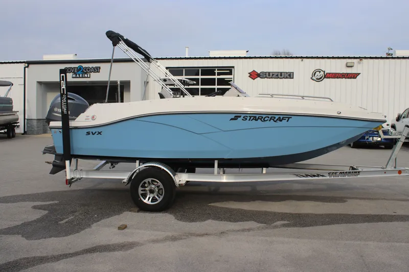 Slide: The Image of 2025 Starcraft SVX 191 OB boat in light blue on a trailer outside a dealership. - 5