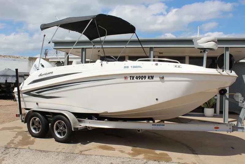 Slide: The Image of 2022 Hurricane SunDeck Sport 192 RL OB boat on trailer, parked outdoors. - 14