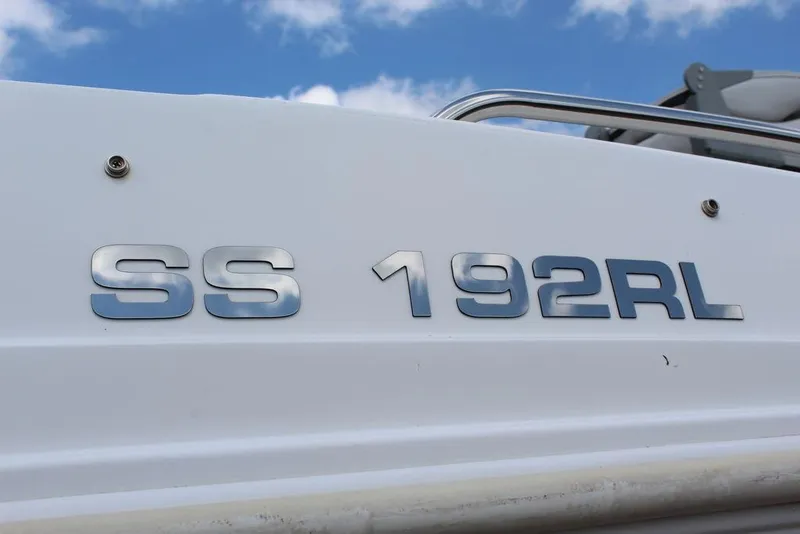 Slide: The Image of 2022 Hurricane SunDeck Sport 192 RL OB boat emblem against blue sky. - 2