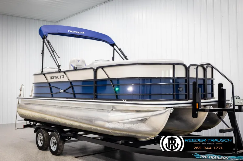 Slide: The Image of 2021 Trifecta 22 CS pontoon boat on trailer in indoor showroom. - 1