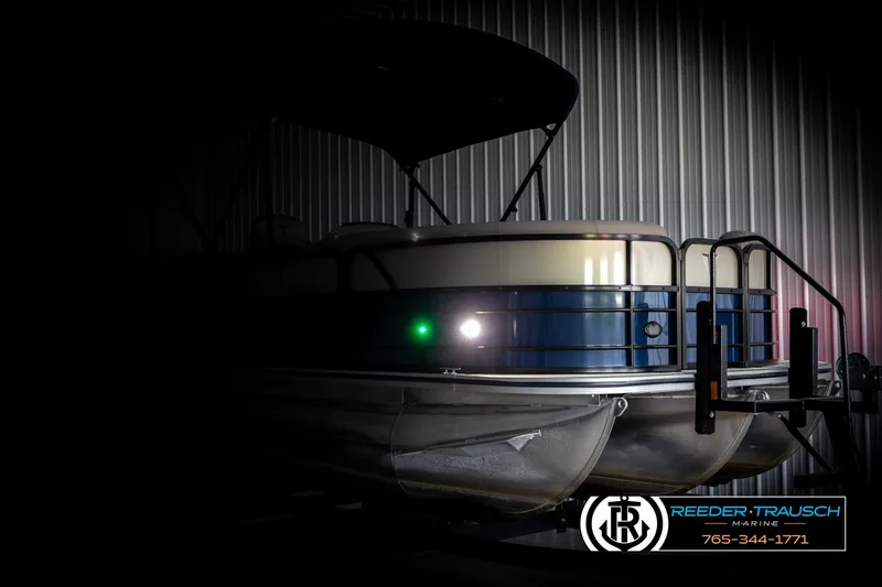 Slide: The Image of 2021 Trifecta 22 CS pontoon boat in dimly lit storage, showcasing sleek design. - 3