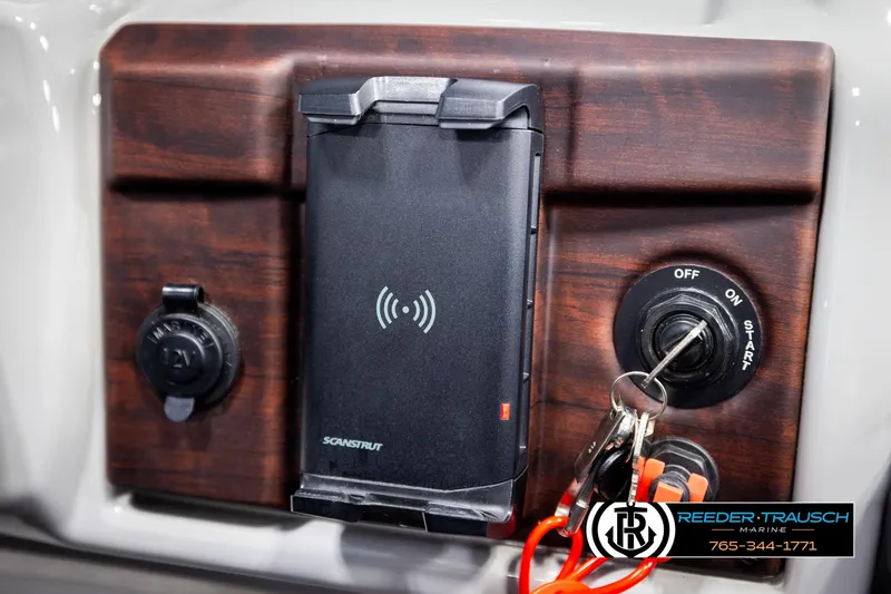 Slide: The Image of Dashboard of 2021 Trifecta 22 CS with wireless charger and ignition keys. - 32