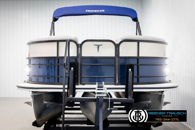 Slide: The Image of 2021 Trifecta 22 CS pontoon boat with blue canopy, displayed indoors. - 7