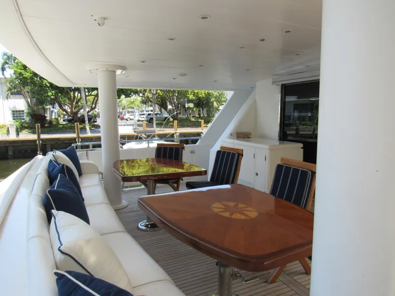 Slide: The Image of Luxurious 2002 Hargrave Raised Pilothouse yacht deck with elegant seating and wooden tables. - 16