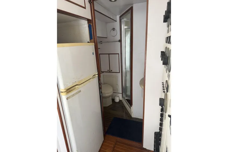 Slide: The Image of Interior of 2002 Hargrave Raised Pilothouse yacht with fridge and bathroom. - 54