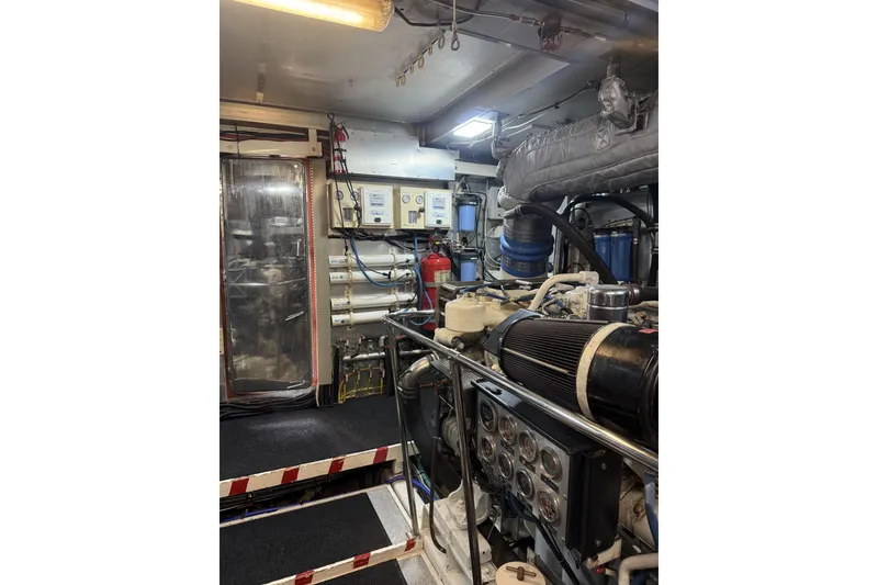 Slide: The Image of Engine room of a 2002 Hargrave Raised Pilothouse yacht, featuring machinery and control panels. - 55