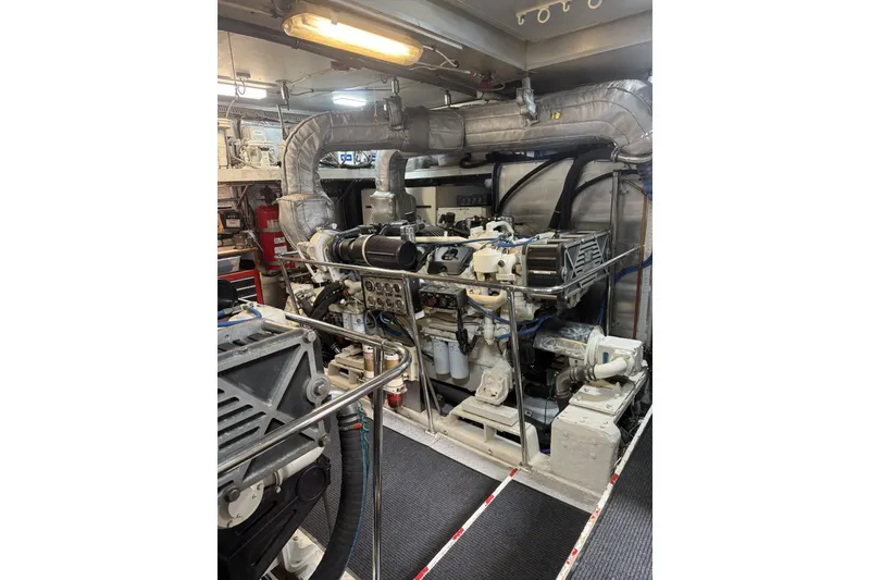 Slide: The Image of Engine room of 2002 Hargrave Raised Pilothouse yacht, showcasing complex machinery and piping. - 59