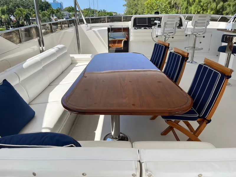 Slide: The Image of Luxurious 2002 Hargrave Raised Pilothouse yacht deck with elegant seating and wooden table. - 9