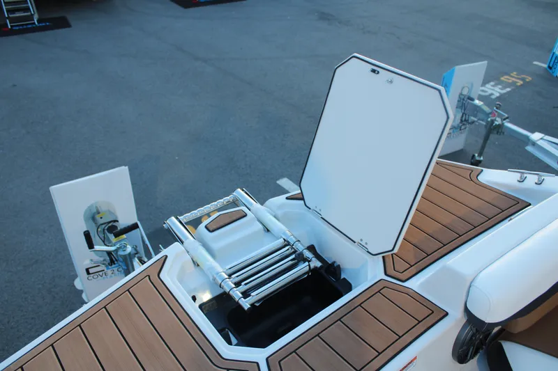Slide: The Image of 2024 Starcraft SVX 211 OB CC boat with open storage compartment and ladder on deck. - 11