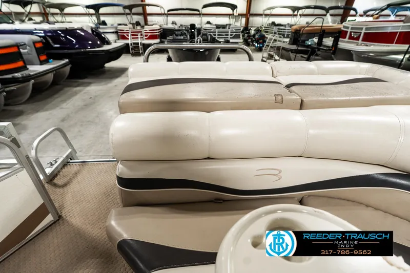 Slide: The Image of 2003 Bennington 2050 RL pontoon boat interior with beige seating in showroom. - 18