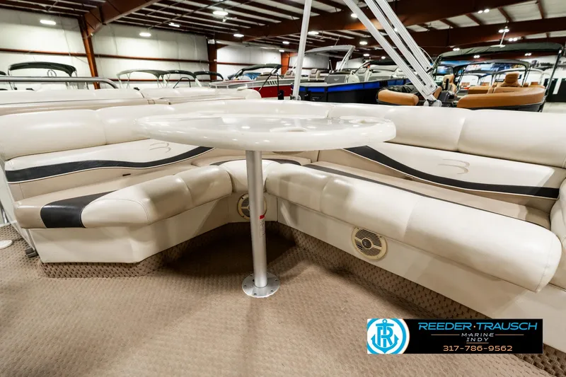 Slide: The Image of 2003 Bennington 2050 RL boat interior with beige seating and table in showroom. - 26