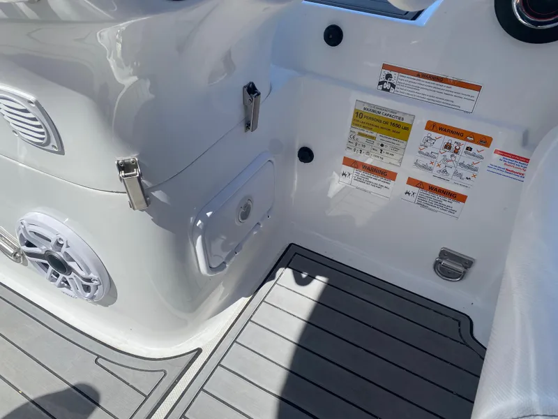 Slide: The Image of 2021 Walker Bay Generation 525 DLX boat interior with safety labels and storage compartment. - 26