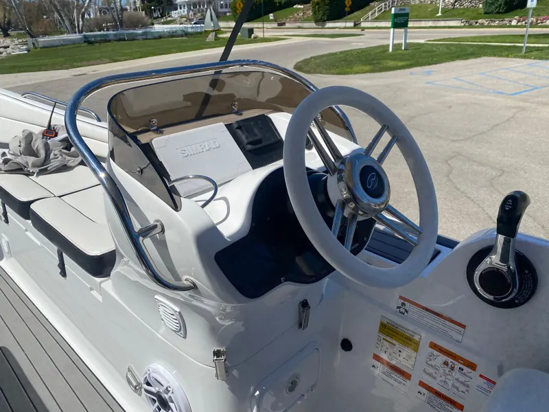 Slide: The Image of 2021 Walker Bay Generation 525 DLX boat console with steering wheel and controls. - 28