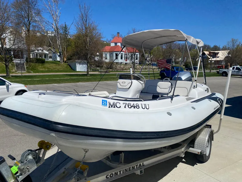 Slide: The Image of 2021 Walker Bay Generation 525 DLX boat on trailer, parked outdoors under clear sky. - 7