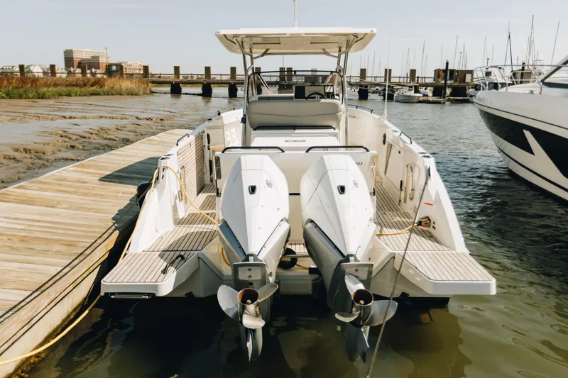 Slide: The Image of 2023 Beneteau Flyer 9 SPACEdeck docked with dual outboard engines, marina background. - 10