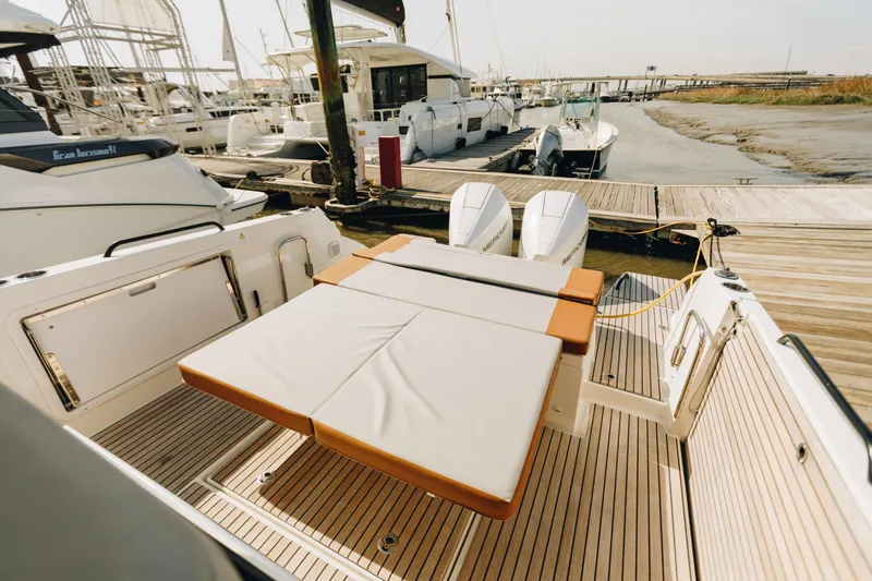 Slide: The Image of 2023 Beneteau Flyer 9 SPACEdeck at marina, featuring spacious deck and twin engines. - 6