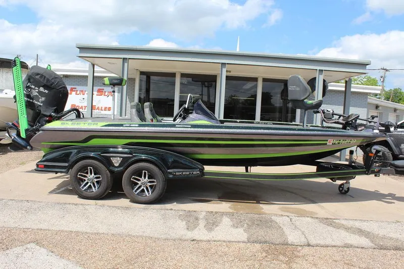 Slide: The Image of 2017 Skeeter FX20 LE boat with green accents parked outside a dealership. - 11