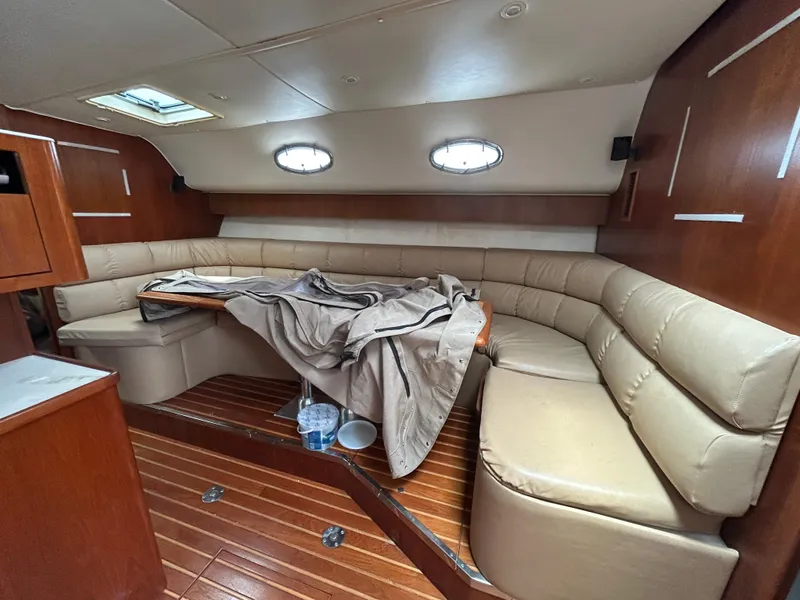 Slide: The Image of 1999 Tiara Yachts 400 Express interior with beige seating and wooden flooring. - 10